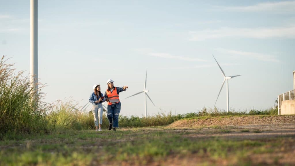 Zwei Ingenieure neben einem Windpark