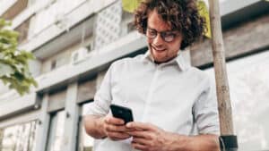 Mann sucht auf seinem Smartphone nach Stellenangeboten in verschiedenen Branchen.